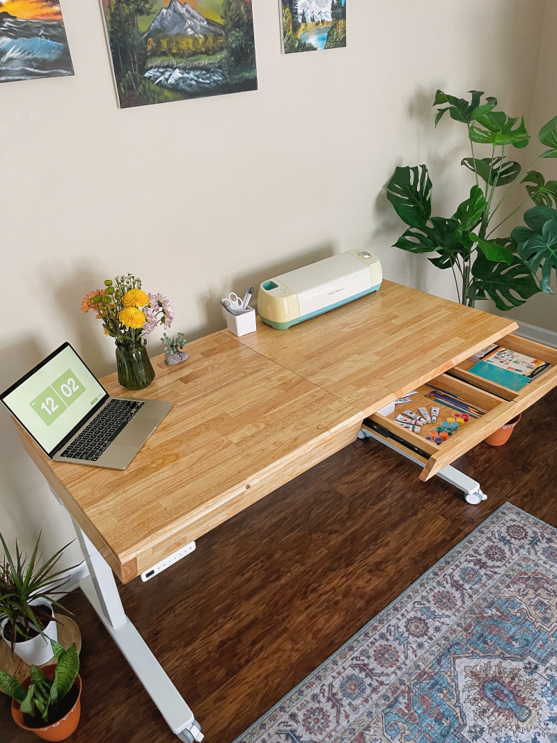 UPLIFT Craft Table in a home craft room with an open drawer holding colored pencils and markers.
