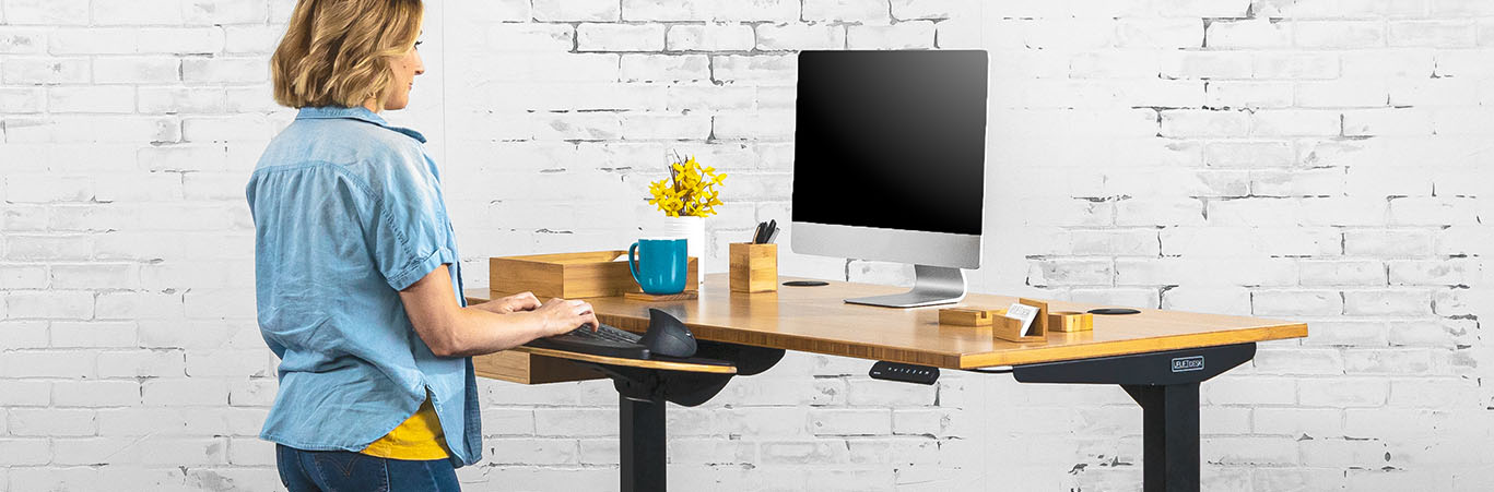 Someone working while standing at a height adjustable desk