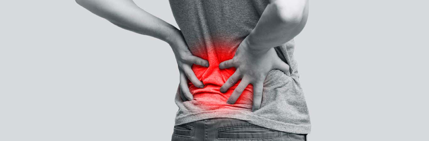 Someone holding their lower back, which is radiating a red color to indicate pain