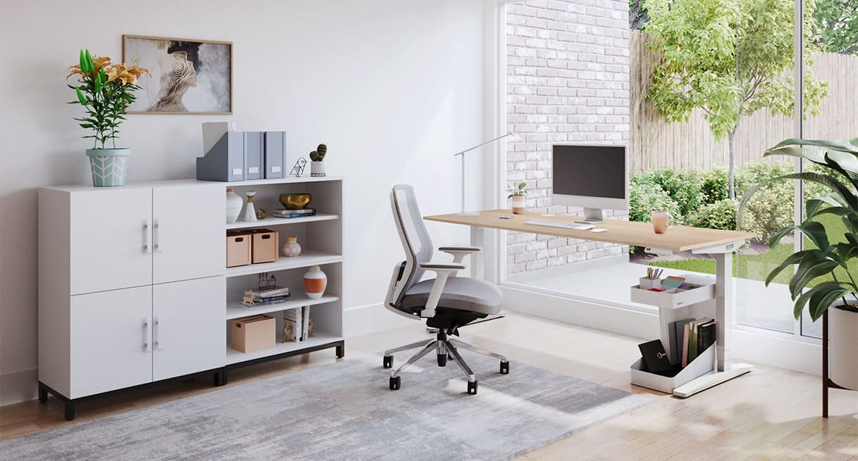 A standing desk set up for online classes with an ergonomic chair, task lighting, space for books, computer, and verdant view