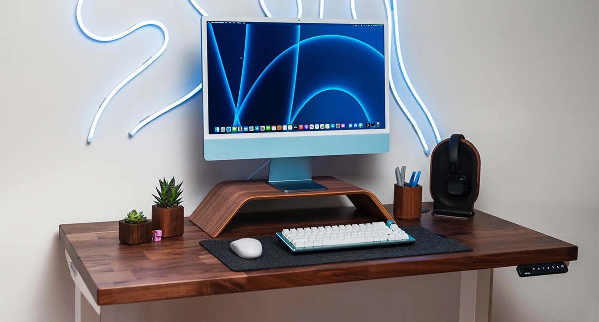 UPLIFT Solid Wood Standing Desk featuring Saman Butcher Block with various desk accessories.