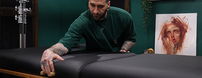 Co-owner of Eden Body Art Studios installing a massage table atop his UPLIFT Desk