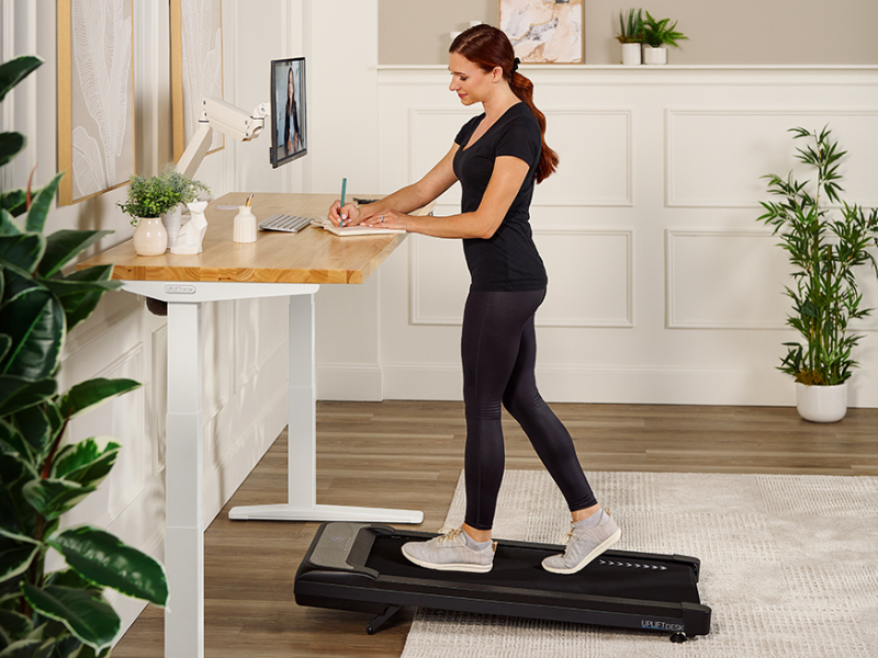 Walking pad paired with a standing desk in a workspace