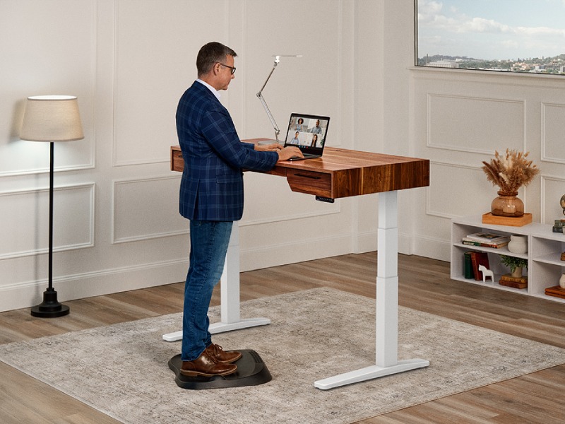 Person standing comfortably on UPLIFT anti-fatigue mat at standing desk