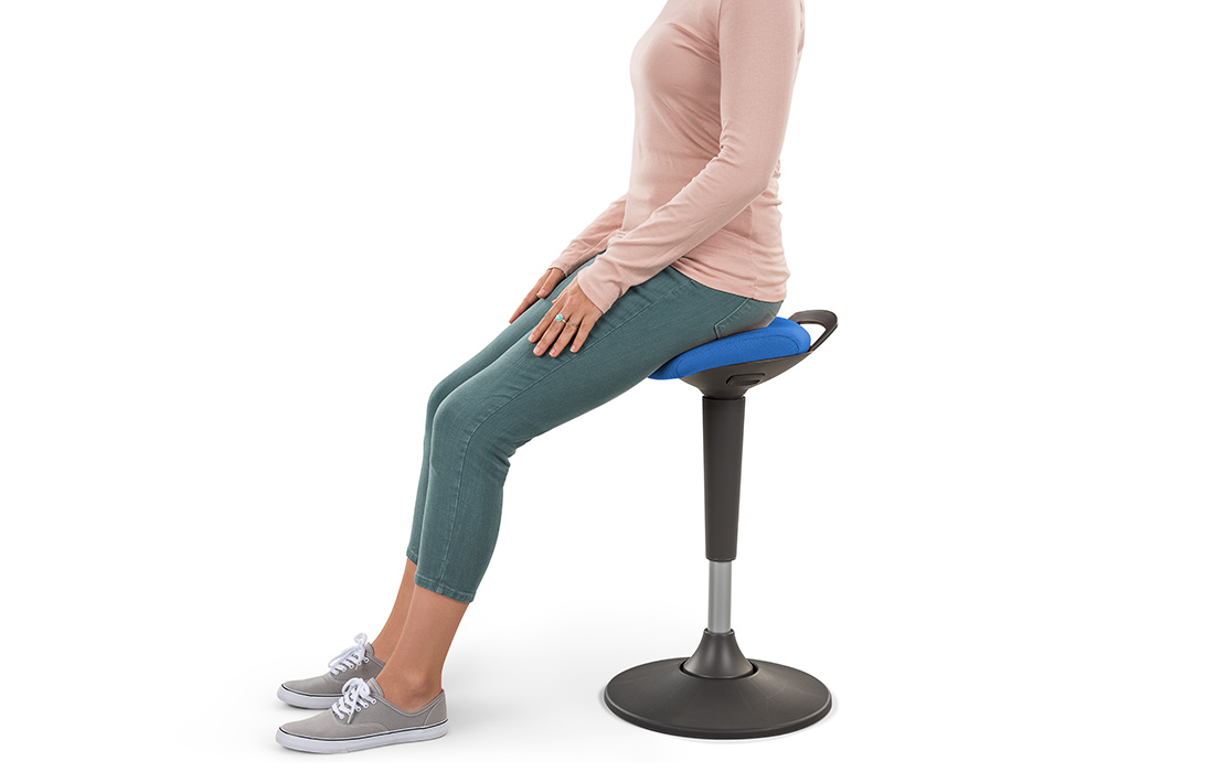 A woman sitting on a blue Starling Stool by UPLIFT Desk