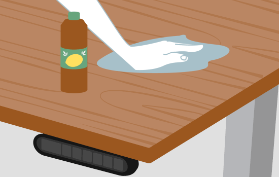 A hand wipes down a desktop with lemon oil to preserve the finish