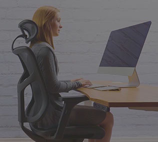 woman tasks comfortably at a standing height adjustable desk by UPLIFT Desk