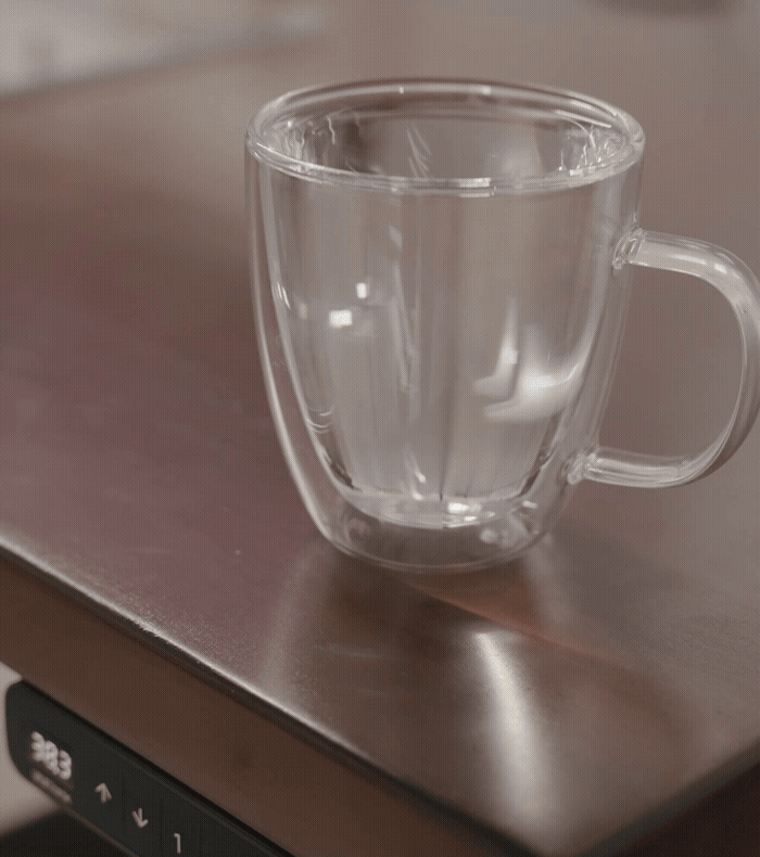 A full glass of water on top of a moving Uplift Standing Desk to demonstrate non-disruptive movement.