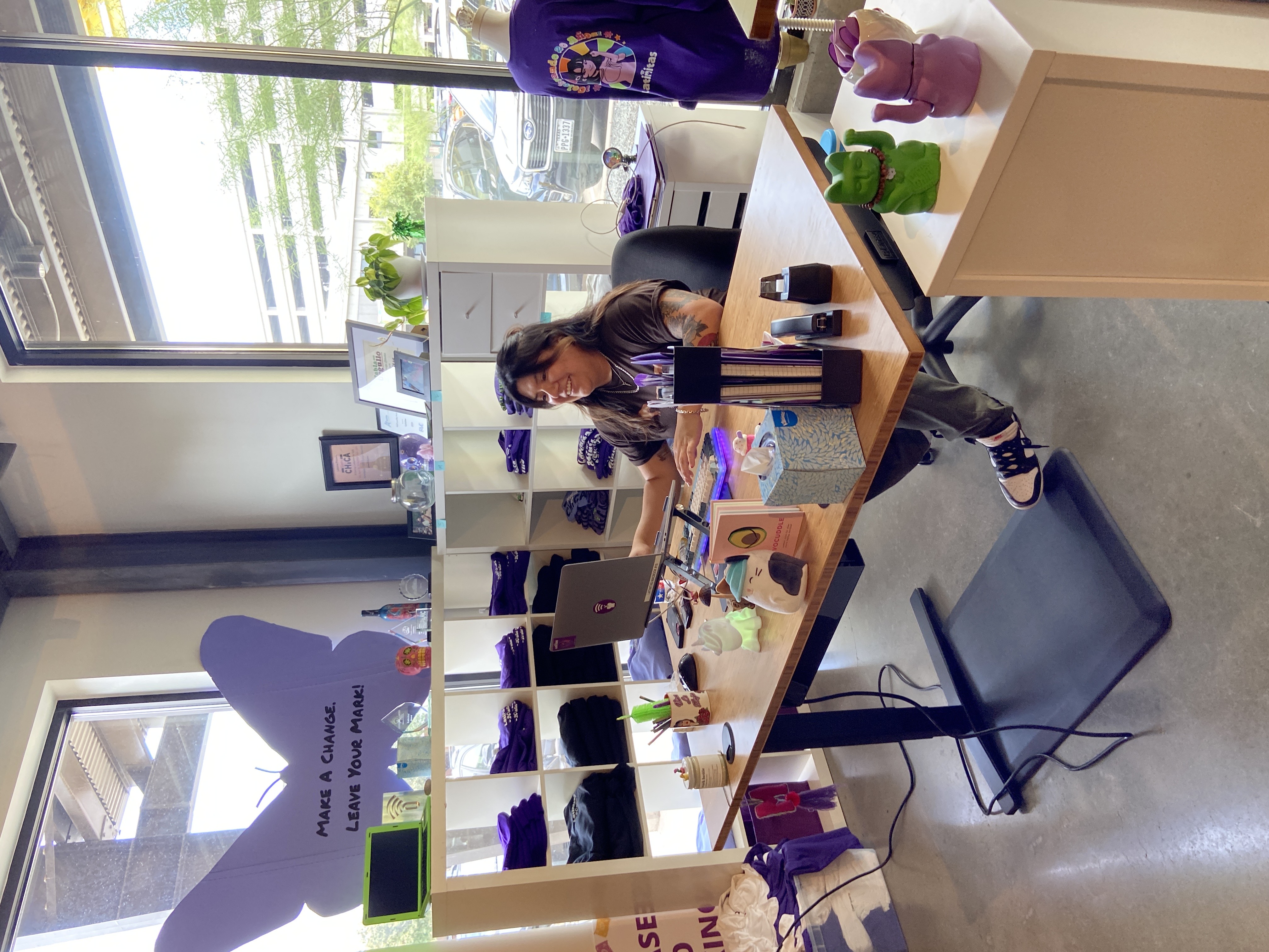 A member of the Latinitas team working at their new UPLIFT Desk V2 Standing Desks with bamboo desktop and foam standing pads on the ground.
